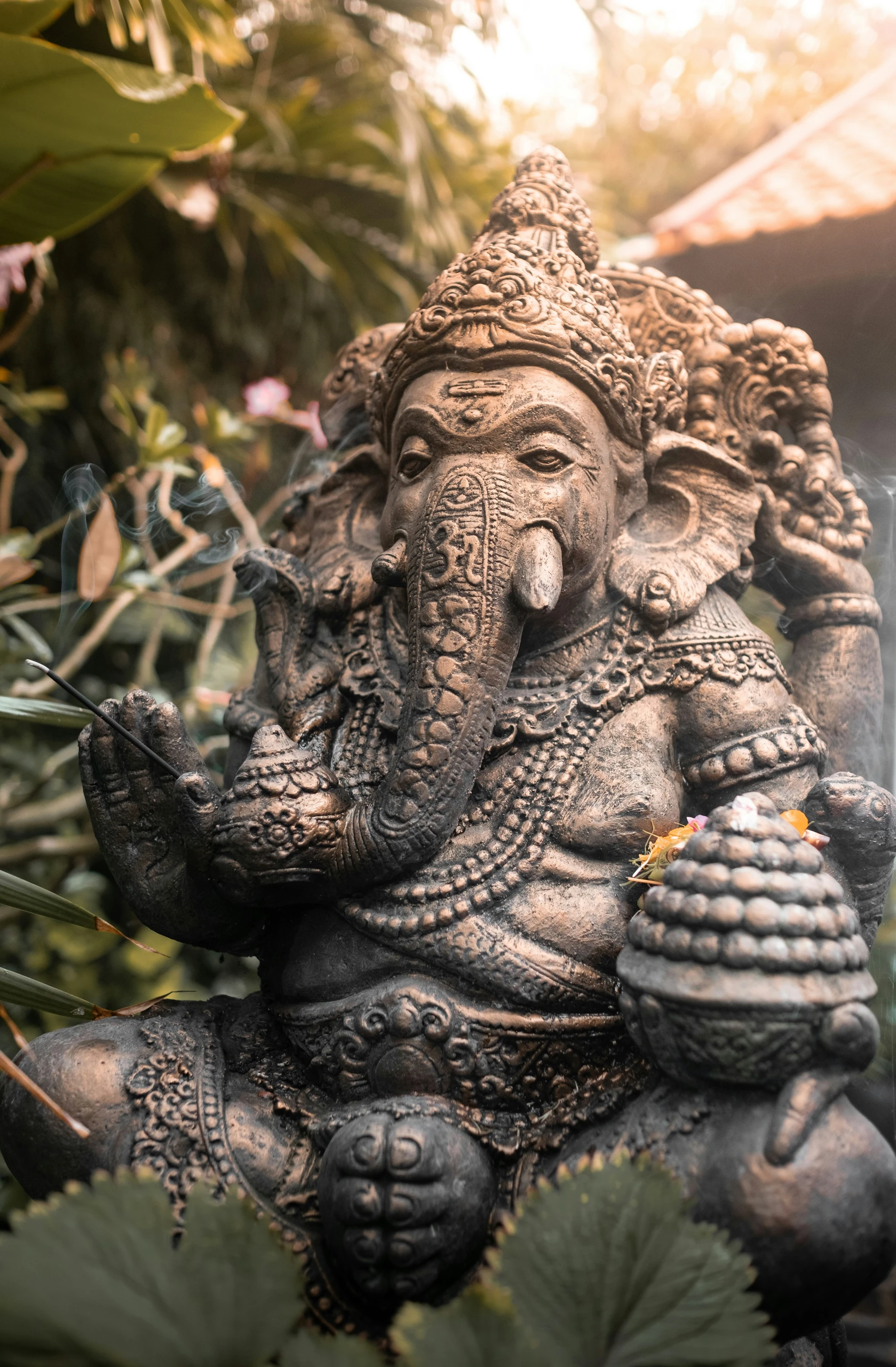 A carved stone statue in a planted garden