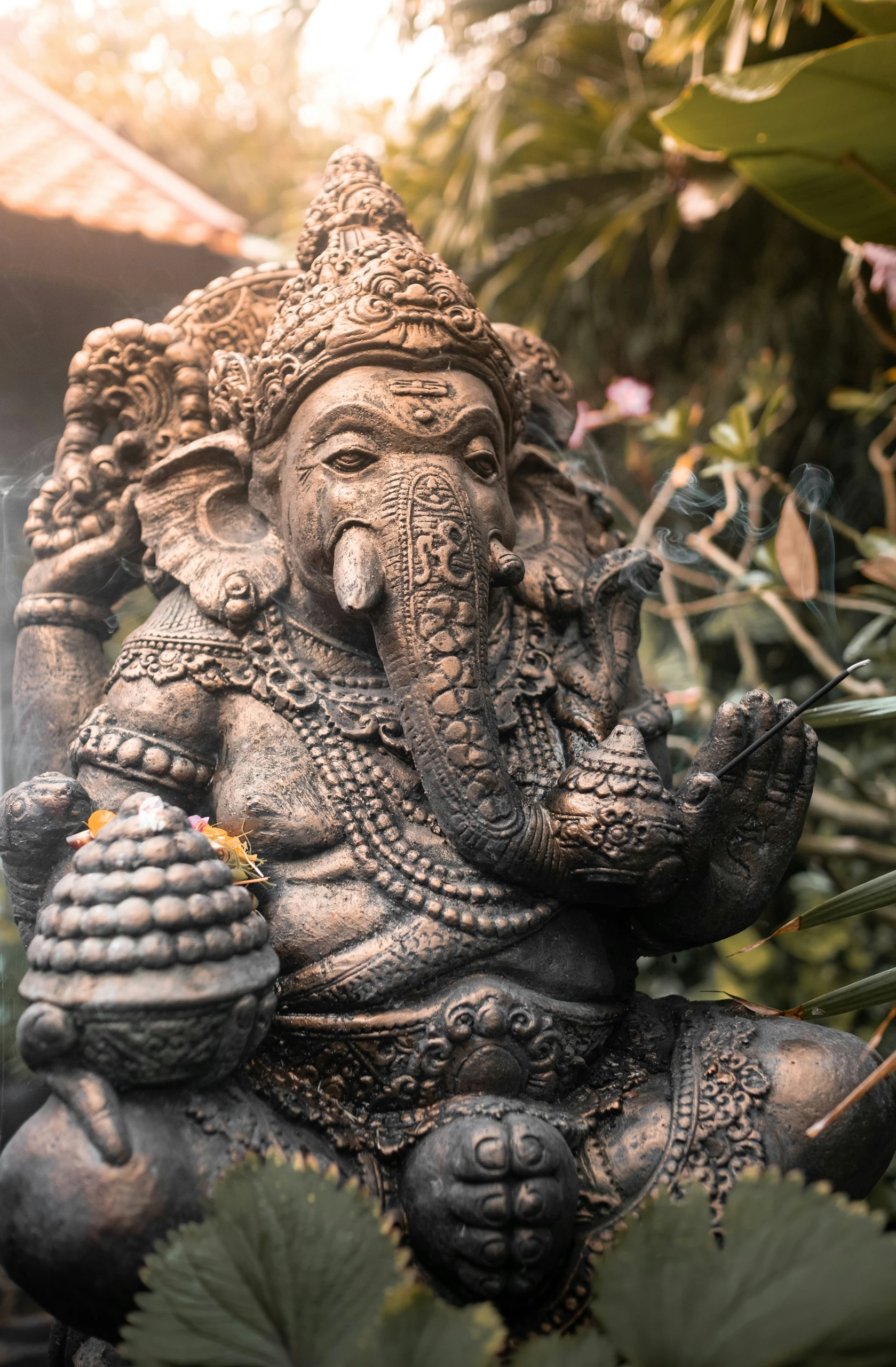 A carved stone statue in a planted garden